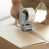 Person using customizes printed acrylic packaging tape on corrugated box for product packaging and shipping